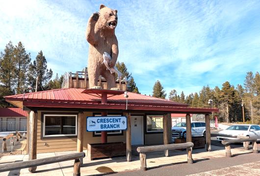 Building with a bear holding a fish and waving. A banner reads "Crescent Branch".