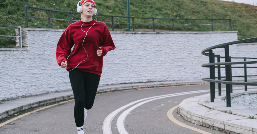 A woman jogs down a sidewalk.
