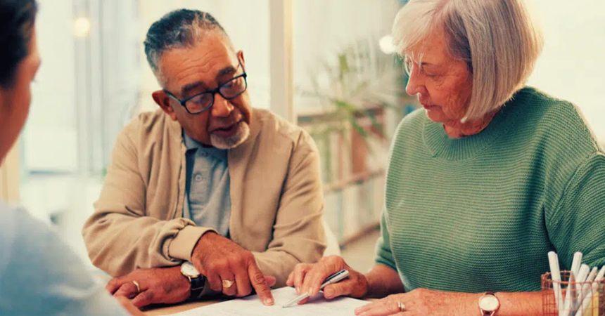 A man and a woman closely examine a legal document.