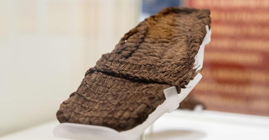 A flat sandal woven from twisted plant fibers.