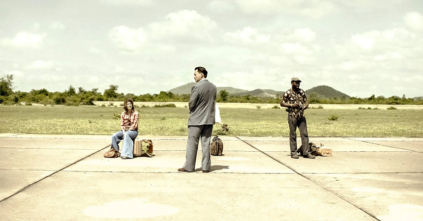 On the poster for Meeting with Pol Pot, the three leads stand on an empty tarmac with their luggage.