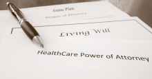 A pile of legal documents labeled "Estate Plan," "Power of Attorney," "Living Will," and "HealthCare Power of Attorney."