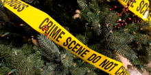 A Christmas tree wrapped in "Crime Scene: Do Not Cross" warning tape.