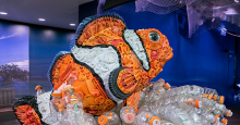 A sculpture of a clownfish made from bits of orange, black and white discarded plastic.