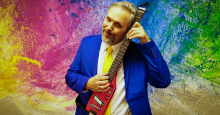 Musician Eric Herman poses with a miniature electric guitar.