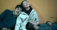 In a scene from The Breaking Ice, two young men and a young woman lean against each other after a night of drunken revelry.