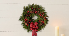 A wreath made of evergreen boughs, pinecones, and red berries.