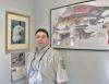 Stephen Rooker stands in front of wildlife art on the wall